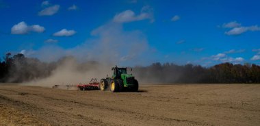 Traktör tarlada toprak sürüyor. Toprak üzerinde çiftçilik. Kırsal tarım arazilerinde traktör. Toprakta çalışan tarım makinesi ya da traktör. Çekici tarla sürme çiftliği. Çiftlik arazisi