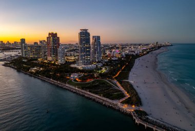 Miami şehir merkezinin gün batımı parlayan manzarası. Güney Sahili 'ndeki tropik cennet. Miami 'de gece yarısı ışıkları. Miami ufuk çizgisinin rıhtım manzarası. Gün doğumunda Miami 'nin hava görüntüsü. Neon Art Deco. Okyanus yolculuğu