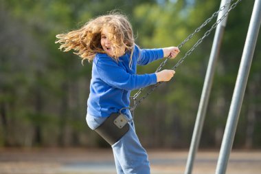Salıncaktaki çocuk. Çocuk bahçesinde mutlu bir çocuk. Kaygısız çocuk dışarıda sallanıyor. Mutlu çocuklar dışarıda oynuyor. Sarışın çocuk mutluluktan uçuyor. Dışarıdaki oyuncu çocuk. Çocuk suratı. Mutlulukla sallanan çocuk