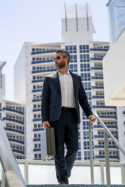 Ofis binasının dışında yürüyen bir iş adamı. İş adamı şehre işe yürüyerek gider. Dışarıda dolaşan takım elbiseli bir yönetici. Ofis çalışanı kendine güvenerek yürüyor. Havalı iş adamı gökdelenlerin önünden geçiyor