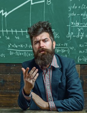 Öğretmen tahtada matematiği açıklıyor. Sınıfta tahtası olan bir öğretmen. Öğretmen matematik formülü yazıyor. Sakallı öğretmen. Profesör sınıfta ders veriyor. Profesör matematiği açıklıyor