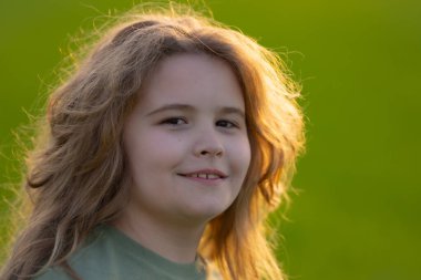 Yazın çekilen çocuk portresi. Çocuk suratı. Mutlu bir çocuğun yaz portresi. Çocuk yüzü parkta. Dışarıdaki neşeli çocuğun portresi. Eğlenceli bir çocuk yüzü. Çocuk yazın tadını çıkarıyor. Yaz titreşimleri