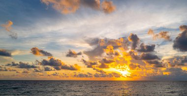 Gün batımında gökyüzü. Ufukta gün doğumu. Gökyüzündeki bulutların arasından gün batımı. Günbatımı renklerinde alacakaranlık gökyüzü. Yumuşak ışıkla huzurlu bir şafak. Bulutlu dramatik alacakaranlık. Açık gökyüzünde gün ışığı