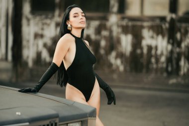 Kıyafetli Moda Kadını 'nın portresi. Seksi hippi kız seni. Garajda şık, şehvetli bir moda kadını. Moda tarzı. Cazibeli moda tarzı. Dışarıda poz veren modaya uygun seksi bir model. Yüksek moda görünüş