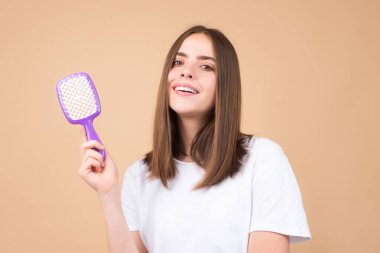 Güzel bir kadın sağlıklı saçlarını tarıyor. Sağlıklı, uzun, düz kadın saçı, yakın çekim.