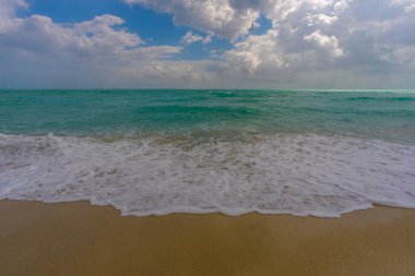 Rahatlatıcı deniz manzarası. Tatil kıyı şeridi. Lüks tatil köyü. Suyun üzerindeki ışık yansıması. Kıyı manzarası. Turkuaz göl. Altın kumlu sahil. Parlak güneş ışığı. Deniz meltemi. Tropik plaj