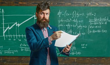 Öğretmen sınıfta matematiği açıklıyor. Profesör, matematik dersinde. Öğretmen matematik formülü yazıyor. Komik öğretmen. Profesör sınıfta ders veriyor. Öğretmen matematiği açıklıyor. Öğretmenler Günü