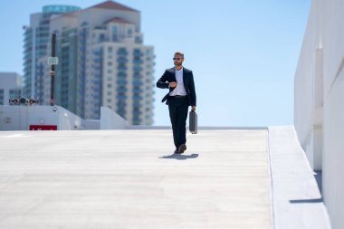 Zengin iş adamı dışarıda dolaşıyor. Çantası olan başarılı bir iş adamı. Şirket lideri harekete geçti. İş adamı güvenle yürüyor. İşadamı işe gidiyor. Takım elbiseli yakışıklı iş adamı.