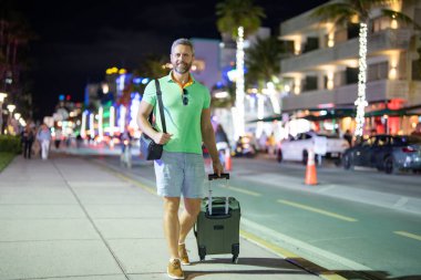 Gezgin ve Amerikan turizmi. Bavulunu toplamış bir gezgin bir gece şehrinde yürüyor. Miami 'de yaz gezisinde bir gezgin. Los Angeles 'ın gece hayatı. Ünlü bir sokakta İspanyol turist.