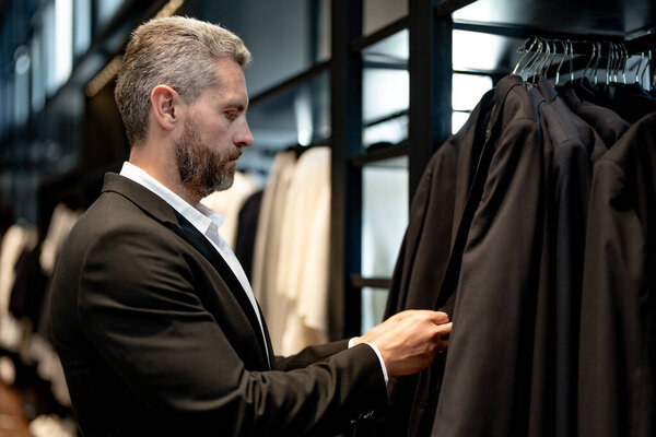 Хорошо сшитый костюм. Стильный деловой костюм для бизнесмена. Клиент выбирает костюм для делового образа. Портрет человека в классическом костюме. Модели для съёмок в журналах