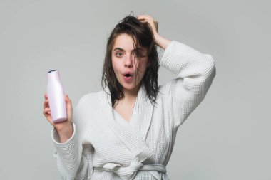 Kadın saç bakımı. Kadın şampuan ve saç kremi tutuyor. Güzellik ürünü. Saç bakım ürünü şampuan şişesi olan esmer kız. Saç bakımı. Saç yerine merhem şişesi olan mutlu genç bir kadın.