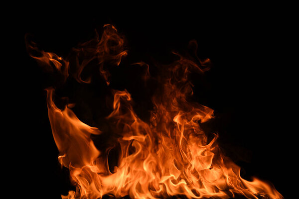 Огненное пламя выделяется на черном фоне. Ожоговое пламя, абстрактная текстура. Арт-дизайн для огненного узора, фактуры пламени