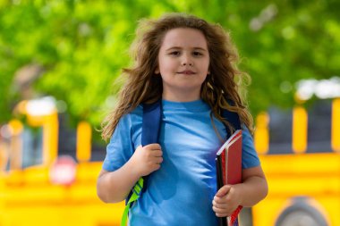 Okul otobüsü dışarıda çocuk öğrenciyi bekliyor. Sırt çantası ve okula gidecek kitapları olan bir çocuk. Devlet okuluna kadar yürüdüm. Amerikan okulunda eğitim, öğrenme ve bilgi kavramı