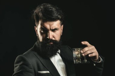 Likör için konyak viskisi. Adam barda tek başına viski içiyor. Likör klasik vintage cam. İnsan eliyle tutulan içki bardağı. İçki dükkânı. Brendi viskisi retro tarzında tatmak