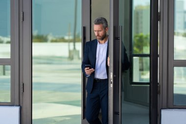 İş adamı bir ofis binasına giriyor. Yetişkin bir iş adamı toplantıya giriyor. Ofis kapısından giren bir iş adamı. Karizmatik iş adamı kapıdan giriyor. İş anlaşması