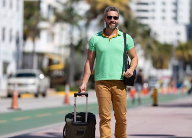 Yalnız seyahat etmek. Tropikal yaz sokağında olgun bir turist. Tüm şehri dolaş. Seyahat çantalı adam. Yaz gezisi. Seyahat seyahati. Yaz, seyahat için mükemmel bir zamandır. Seyahat eden insanlar