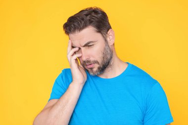 Düşünen düşünceli bir adam düşünceli bir şekilde kenara bakar ve planlarını sarı arka planda izole eder. Yakışıklı düşünen bir adam düşünüyor. Düşünen bir adamın portresi. Düşünceli adam karar vermeyi düşünüyor.