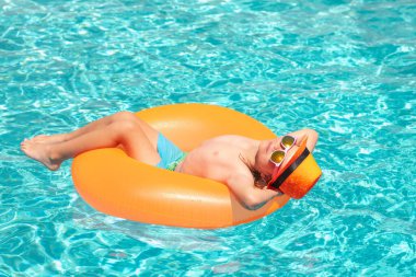 Komik çocuklar yaz suratı. Çocuklar yaz tatilinde yüzme yüzüğüyle yüzerler.