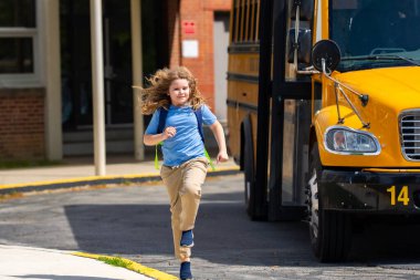 Okul otobüsü dışarıda çocuk öğrenciyi bekliyor. Sırt çantası ve okula gidecek kitapları olan bir çocuk. Devlet okuluna kadar yürüdüm. Amerikan okulunda eğitim, öğrenim ve bilgi kavramı