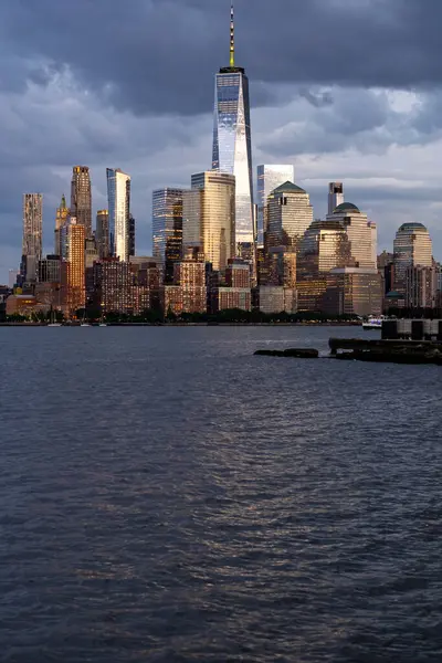 New York şehri. New York şehir manzarası. New York 'taki Lower Manhattan ve One World Trade Center. Manhattan 'ın gökdelenleri New York körfezinin dalgalanan sularının yanında mavi gökyüzüne karşı. New York gökdelenleri