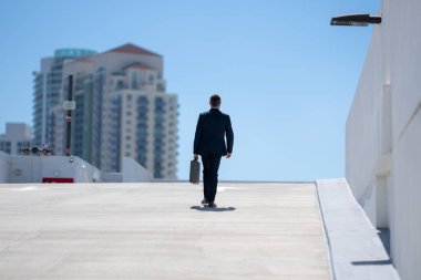 Evrak çantasıyla yürüyen bir iş adamı. İşadamı çekip gidiyor. Şirket lideri git buradan. Çantalı takım elbiseli adam. Profesyonel bir iş adamı. Kentsel iş adamı