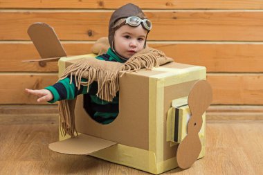 Çocuk hayal gücü kavramı. Hayali kanatlı bebek sineği. Çocukların hayal gücü macerası. Hayalperest çocuk uçmayı hayal eder. Karton kanatlar hayal gücünü harekete geçirir. Yaratıcı çocuk pilot hayal gücü