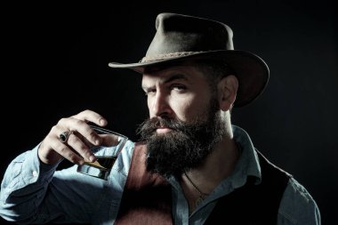 Sakallı adamın tuttuğu konyak bardağı. Barda yalnız başına konyak içen adam. Klasik bardakta viski konyağı. Konyak retro tarzında tatmak. Pahalı viski. Viski konsepti iç. Alkolik içecek.