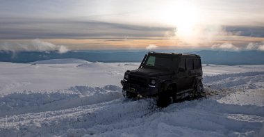 01.02.2021, Karpatlar. Gün batımında kar içinde off-road SUV. 4x4 jipli bir kış seferi. Kış doğasında zorlu bir off-road gezisi. Kış off-road. Kar yolunda macera gezisi. Kış yolları