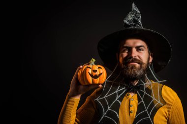 Cadılar Bayramı balkabaklı komik bir model. Cadılar Bayramı şapkalı balkabaklı insan portresi. Şeker mi şaka mı? Cadılar Bayramı şapkalı korkunç hippi. Cadı şapkalı adam balkabağını tutuyor. Mutlu Cadılar Bayramı