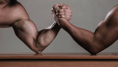 Bilek güreşi. Bilek güreşi, rekabet. Erkek eli ya da kolları. Rekabet, erkek bilek güreşine yakın çekim. İki elle. Kuvvetlerini ve kollarını ölçen kaslı adamlar. El güreşi yarışması. Güçlü kollar. Güç eli.