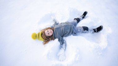 Kar meleği yapan bir çocuk. Karda yatan mutlu çocuk. Kardaki melek çocuk. Karlı melek kanatlı kış çocukları. Karlı bir günde gülümseyen bir çocuk. Kar Gölü Meleği 'ndeki kaygısız çocuk. Noel neşesi