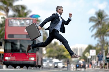 İş atlayışı. Caddeye atlayan komik iş adamı. Takım elbiseli bir işadamı geç kaldı ve atladı. Sıçrama hareketiyle meşgul bir iş adamı. Kendine güvenen işadamı heyecanla zıplıyor.