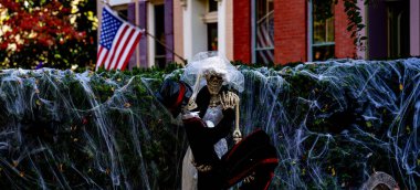 Cadılar Bayramı süslemeleri. Amerikan evi için Cadılar Bayramı balkabağı ve iskeleti. Bir Amerikan evinin ön bahçesinde dekore edilmiş korkunç bir şey. Şeker mi şaka mı? Amerika 'da Cadılar Bayramı. Amerika 'da Cadılar Bayramı