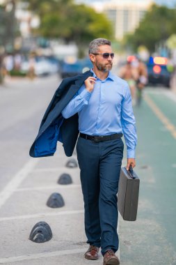 İş adamı işe yürüyerek gider. İspanyol işadamı sokakta güvenle yürüyor. Ofis çalışanı ofise gidiyor. Orta yaşlı iş adamı şehirde yürüyor. Yazlık kıyafetli bir iş adamı.
