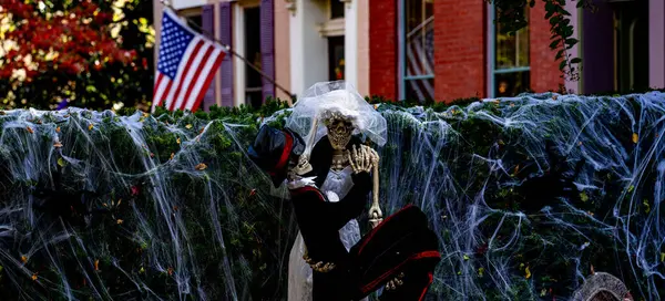 Cadılar Bayramı süslemeleri. Amerikan evi için Cadılar Bayramı balkabağı ve iskeleti. Bir Amerikan evinin ön bahçesinde dekore edilmiş korkunç bir şey. Şeker mi şaka mı? Amerika 'da Cadılar Bayramı. Amerika 'da Cadılar Bayramı