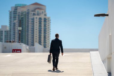 Evrak çantasıyla yürüyen bir iş adamı. İşadamı çekip gidiyor. Şirket lideri git buradan. Çantalı takım elbiseli adam. Profesyonel bir iş adamı. Kentsel iş adamı işe gidiyor.