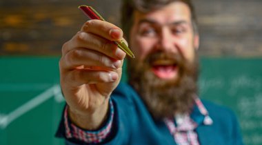 Öğretmen sınıfta matematiği açıklıyor. Profesör, matematik dersinde. Öğretmen matematik formülü yazıyor. Sakallı öğretmen. Profesör sınıfta ders veriyor. Öğretmen matematiği açıklıyor. Öğretmenler Günü