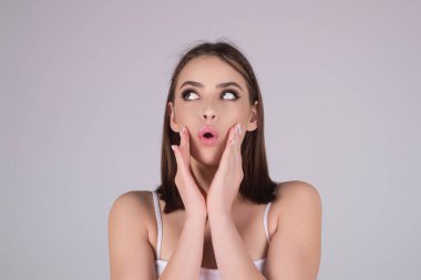 Emotional student girl shocked with news covering mouth with hands. Young emotional woman. The human emotions, facial expression concept. Amazed girl with shocked facial expression