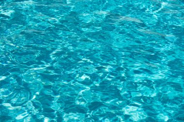 Yüzme havuzunda güneş yansımalı dalgalı su. Dalgalı su arkaplanı