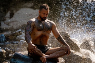 Kaslı adam temiz hava soluyor. Seksi erkek doğada dinleniyor. Sağlıklı gövde güçlü beden güçlü akıl. Doğa üzerine kaslı fitness modeli. Doğada spor. Fiziksel ve zihinsel bakım. Ahenkli spor modeli