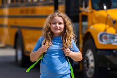 Okula dönelim. Genç öğrenciler için okul başlıyor. Okul otobüsünün yanında sırt çantalı bir çocuk. Çocuk okula gidiyor. Çocuk derse gidiyor. Okul çocuğu.