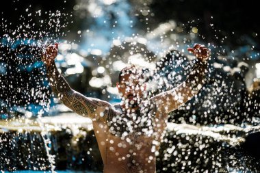 Sağlıklı yaşam güçlü adam açık havada. Formda kaslı erkek yaz portresi. Doğadaki sağlıklı yaşam tarzı adamı. Atletik adam su sıçratıyor. Sağlıklı bir adam. Fitness yaşam tarzı. Sağlıklı bir vücut. Doğadaki adam