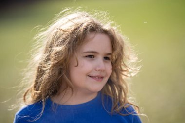 Çayırda kaygısız bir çocuk. Çocuk hayalleri. Hayalperest bir çocuğun açık hava portresi. Çocuklukta özgürlük ve masumiyet. Dışarıdaki şirin çocuk portresi. Hayalci çocuk suratı. Tasasız çocukluk. Hayalci çocuk.