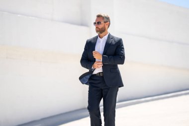 Dışarıda yürüyen bir iş adamı. Takım elbiseli başarılı bir iş adamı. Takım elbiseli kendine güvenen bir iş adamı. İşadamı çekip gidiyor. Zarif takım elbiseli zengin adam. Kendine güveni olan bir iş adamı. Başarı işi