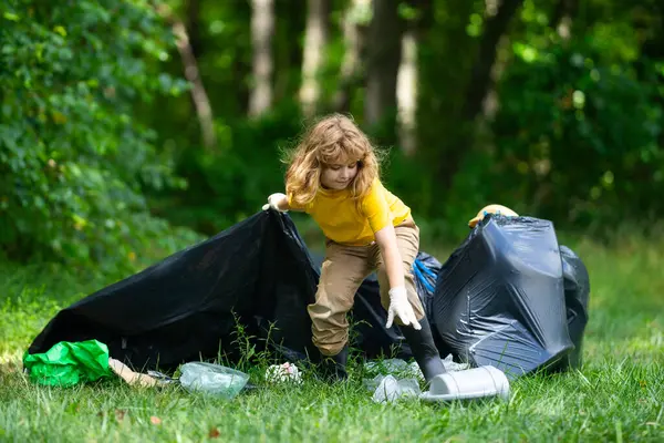 Çocuk doğayı temizlemek için plastik çöp topluyor. Çocuk dışarıdaki çöpleri temizliyor. Ekoloji konsepti. Çevre Günü. Dünyayı kurtar. Çöp geri dönüşüm çöpü. Ekoloji. Çevresel bakım. Eko çocuk