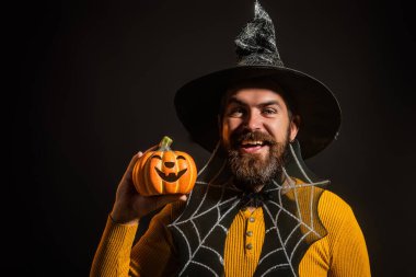 Cadılar Bayramı balkabaklı komik bir model. Cadılar Bayramı şapkalı olgun bir adamın kabaklı portresi. Şeker mi şaka mı? Cadılar Bayramı şapkalı korkunç hippi. Cadı şapkalı adam balkabağını tutuyor. Mutlu Cadılar Bayramı