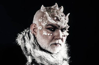 Şeytan boynuzlu adam. Gizemli adam, boynuzlu şeytan. Kara boynuzlu efsanevi şeytan portresi. Ürkütücü yüz. Cadılar Bayramı şeytanı bakışı. Cehennemden gelen kötülük. Doğaüstü güçleri olan bir büyücü. Ürkütücü yüz.