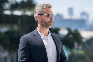 İş adamı kendinden emin duruyor. Başarılı bir iş adamı. Takım elbiseli bir yönetici. Yakışıklı iş adamı kendinden emin görünüyor. Şehir ortamında Orta Doğulu bir iş adamı. Ofis yakınlarında olgun bir işadamı