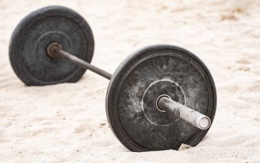 Halter spor ekipmanları. Spor geçmişi. Yaz sporu için kumda halter. Kum arka planda halter. Spor salonunda halterle idman yapıyorum. Halter pankartı