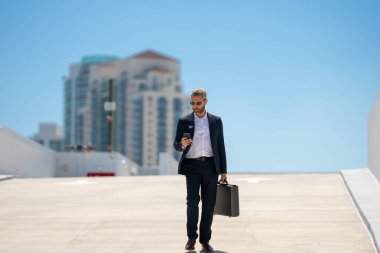 Zengin iş adamı dışarıda dolaşıyor. Çantası olan başarılı bir iş adamı. Lider harekete geçti. İş adamı güvenle yürüyor. Takım elbiseli bir iş adamı işe gidiyor. İş adamı profesyonel hareket halinde